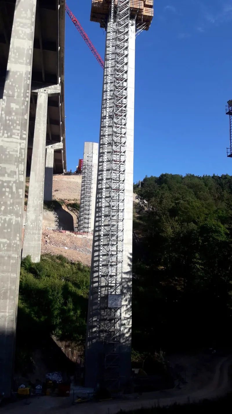 Zwei Brückenpfeiler im Tal, einer davon über die gesamte Höhe eingerüstet
