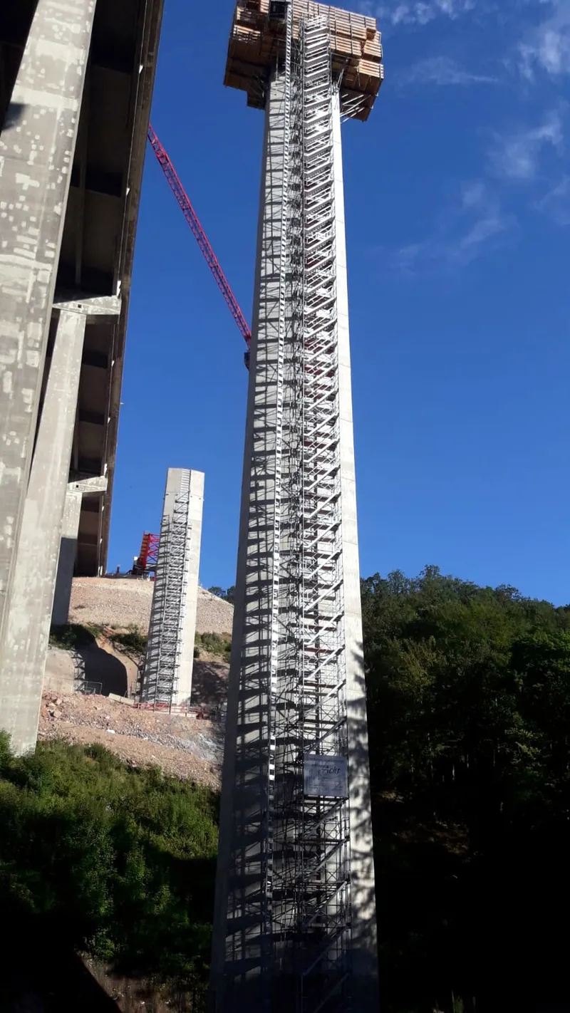 Talbrückenpfeiler über die volle Höhe mit einem Turmgerüst umschlossen, Kran im Bild