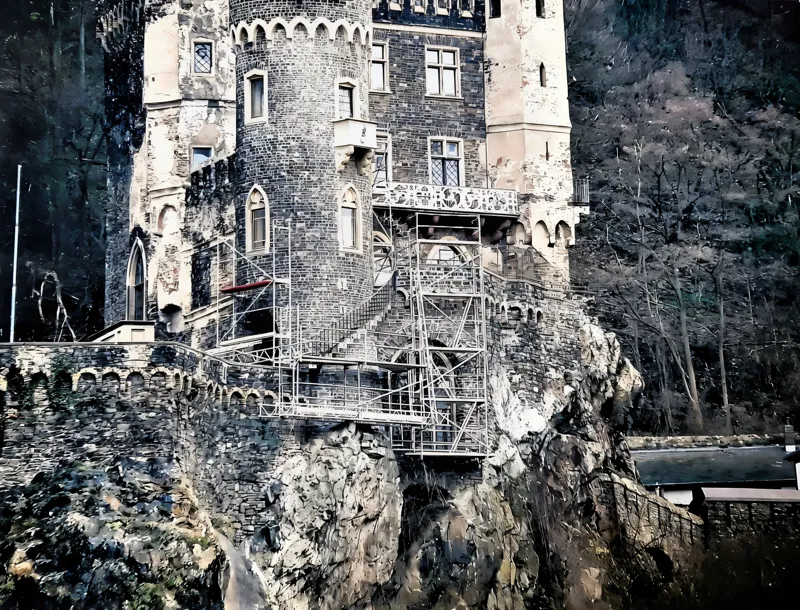 Burg auf einem Felsen über dem Rhein, an der Talseite über den Fels eingerüstet