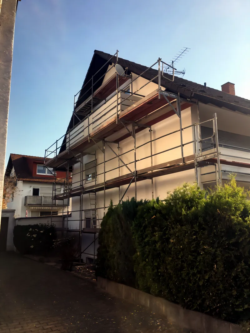 Wohnhaus mit Gerüst an Traufseite und Giebel, Fassade frisch verputzt
