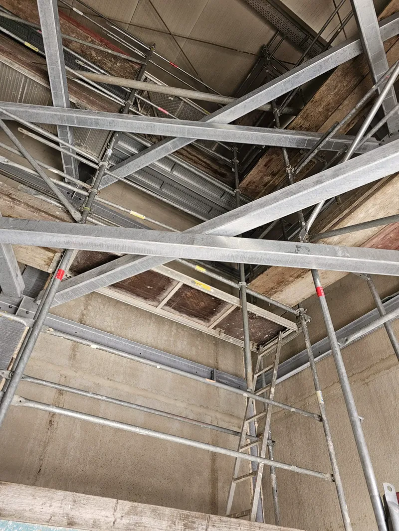 Raumgerüst in einer Halle mit Gitterträgern, Belägen und Diagonalen unter der Decke