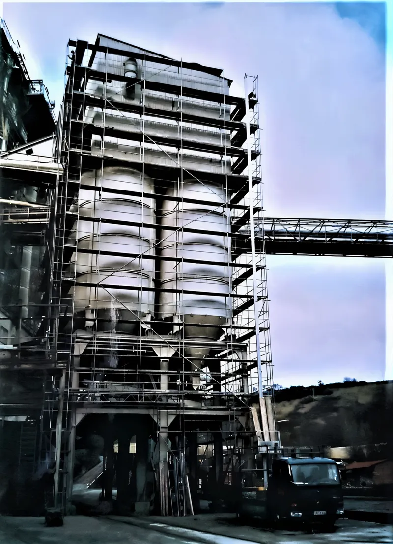 Hohes Anlagengebäude eines Kalkwerks, über die volle Höhe und mehrere Ebenen eingerüstet